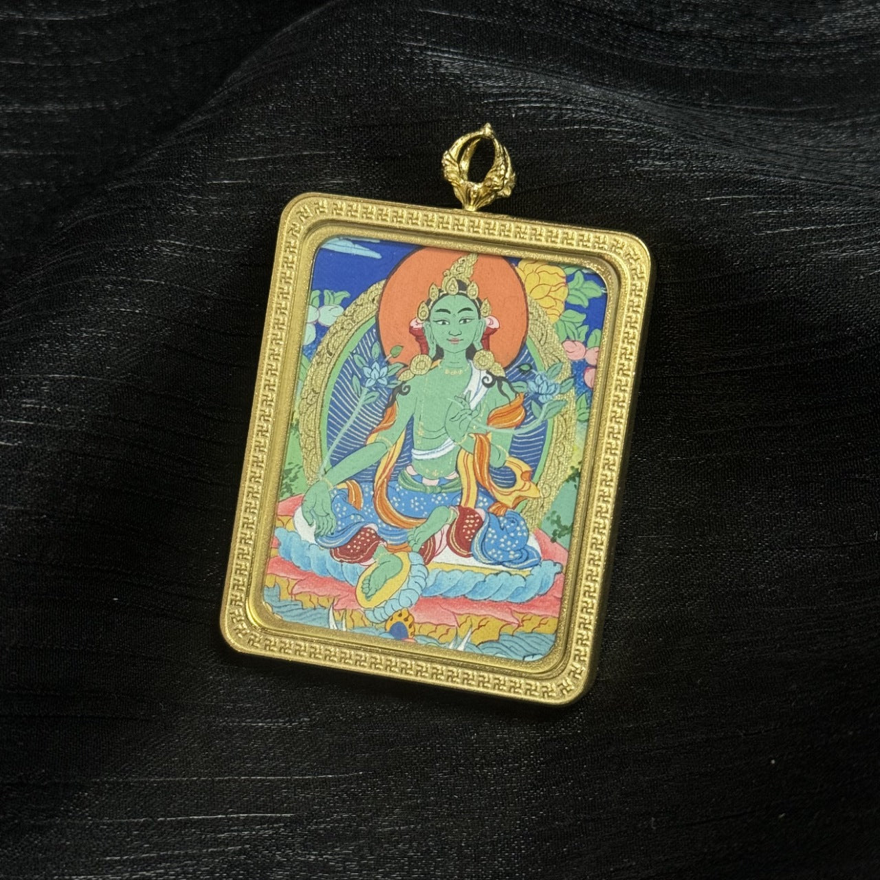 Hand painted Green Tara mini thangka pendant in protective titanium steel frame, traditional Tibetan Buddhist devotional artwork.