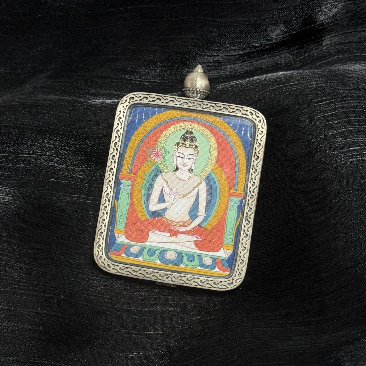 Hand painted Mahasthamaprapta Bodhisattva thangka pendant showing traditional Tibetan Buddhist iconography in a portable devotional artwork.