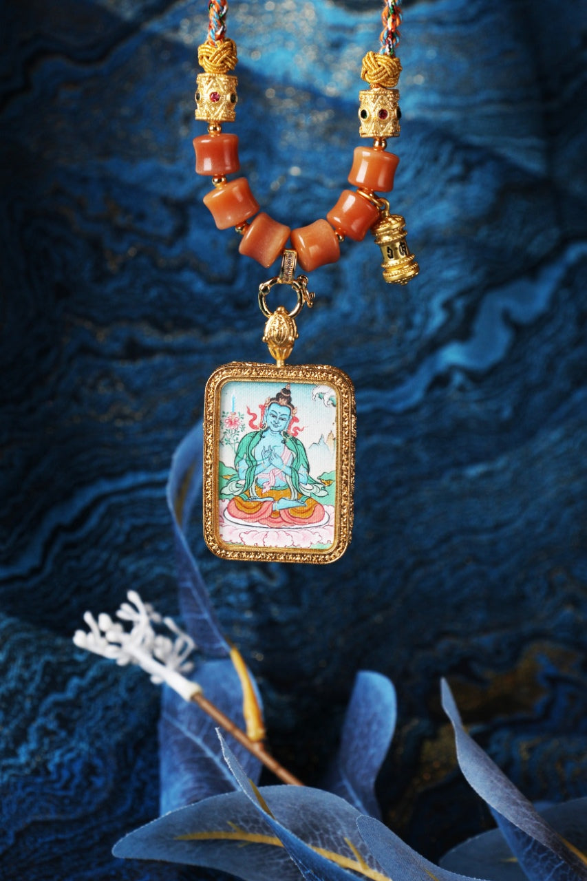 Hanging display of Akashagarbha Bodhisattva mini thangka pendant with rectangular textured metal frame, braided cords, bead segments, and a double-sided protective pendant structure