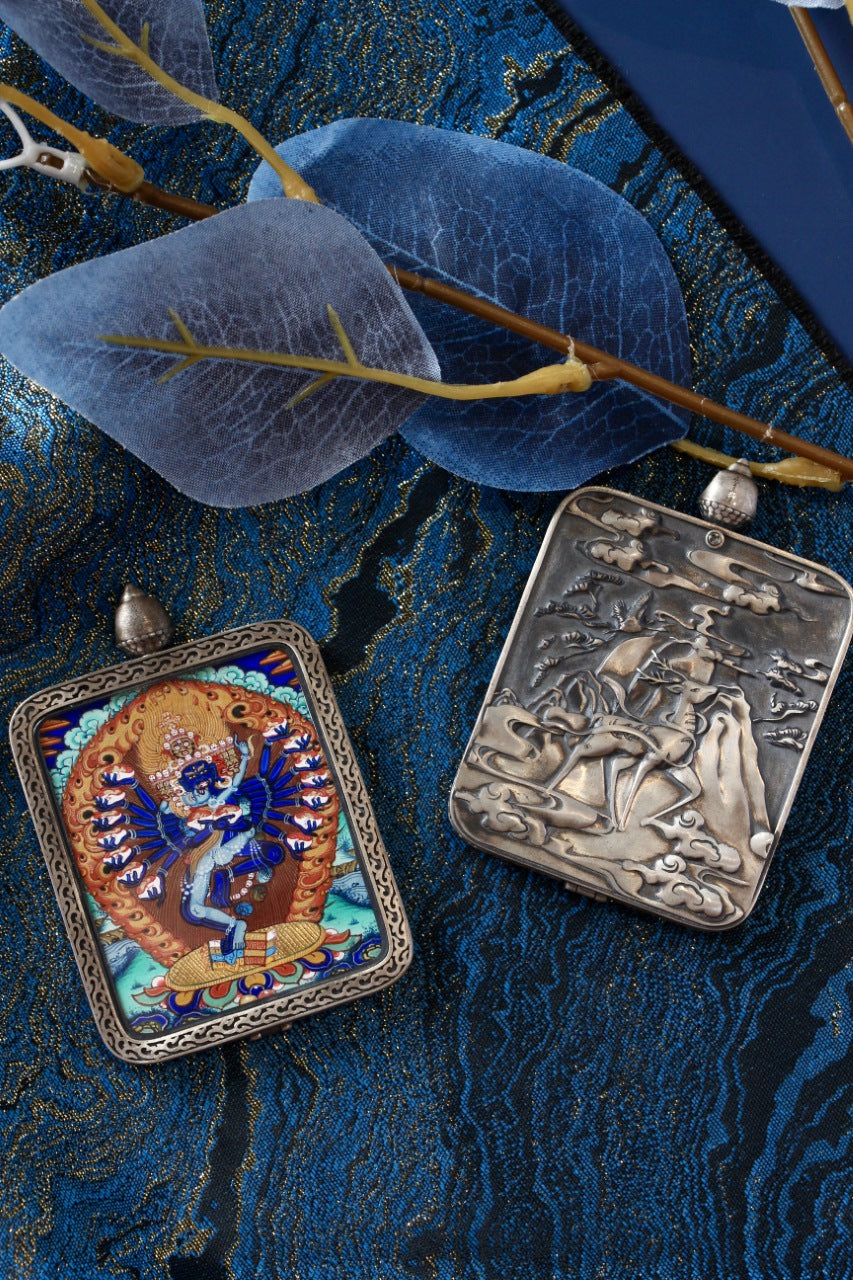 Front and back display of a Hevajra mini thangka pendant, showing the hand-painted thangka image on the front and an engraved pure silver back plate inspired by Dunhuang art motifs.