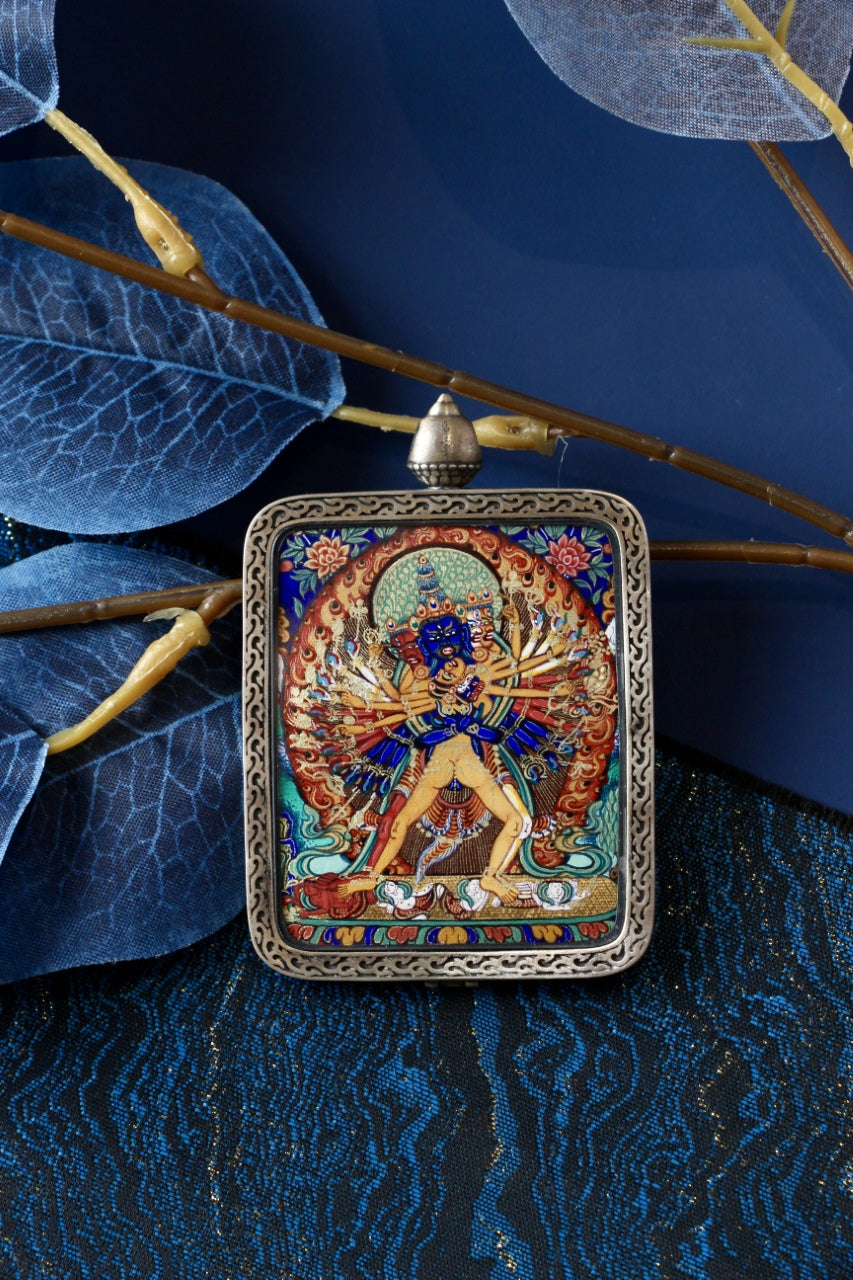 Hand-painted Kalachakra Vajra thangka pendant from Rebgong, depicting the multi-armed Kalachakra deity in union form, painted with natural mineral pigments and set in a silver case.