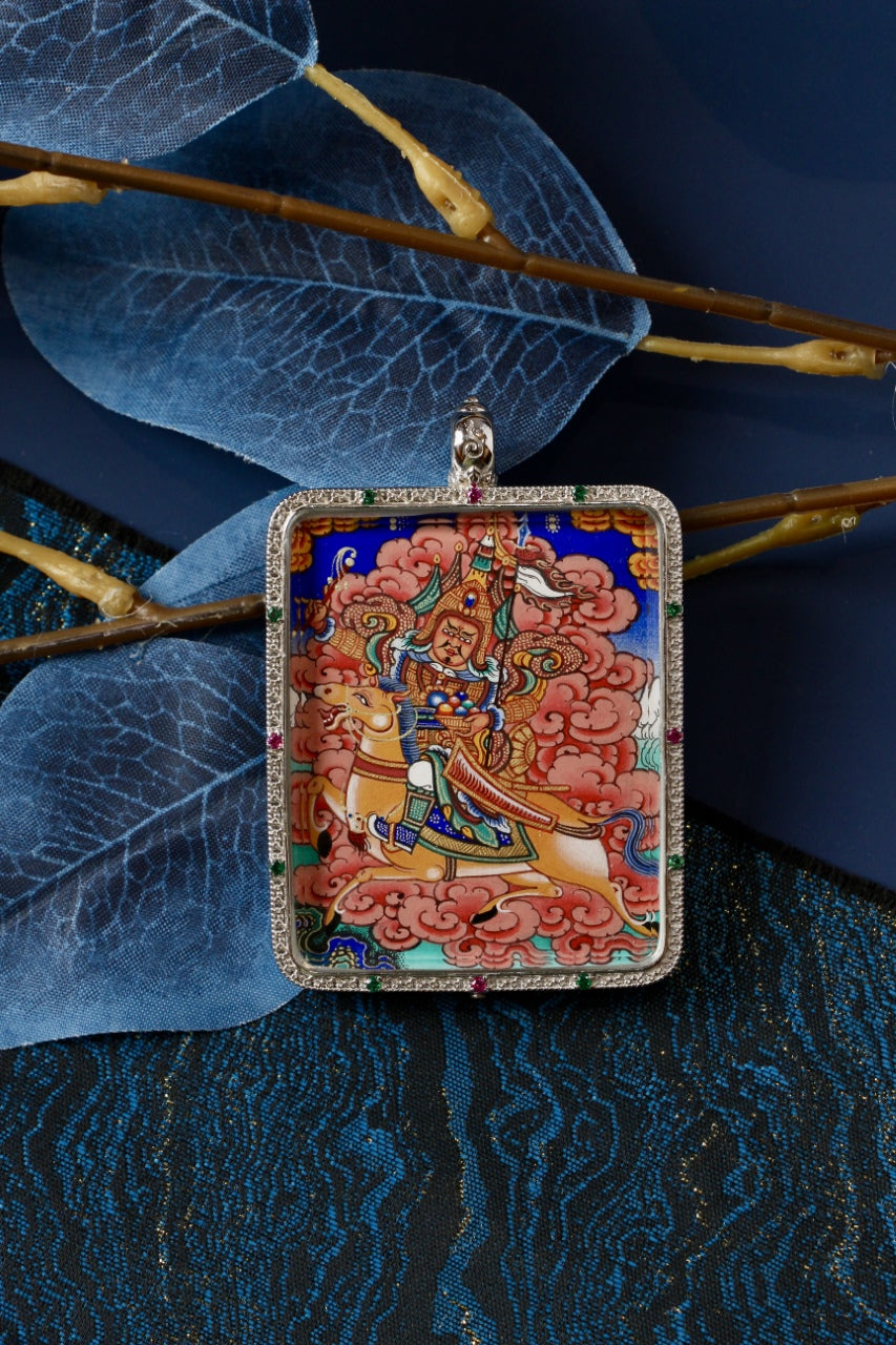 King Gesar hand-painted mini thangka pendant in a 925 silver gawu case, shown as a travel-size devotional pendant on a styled blue background.