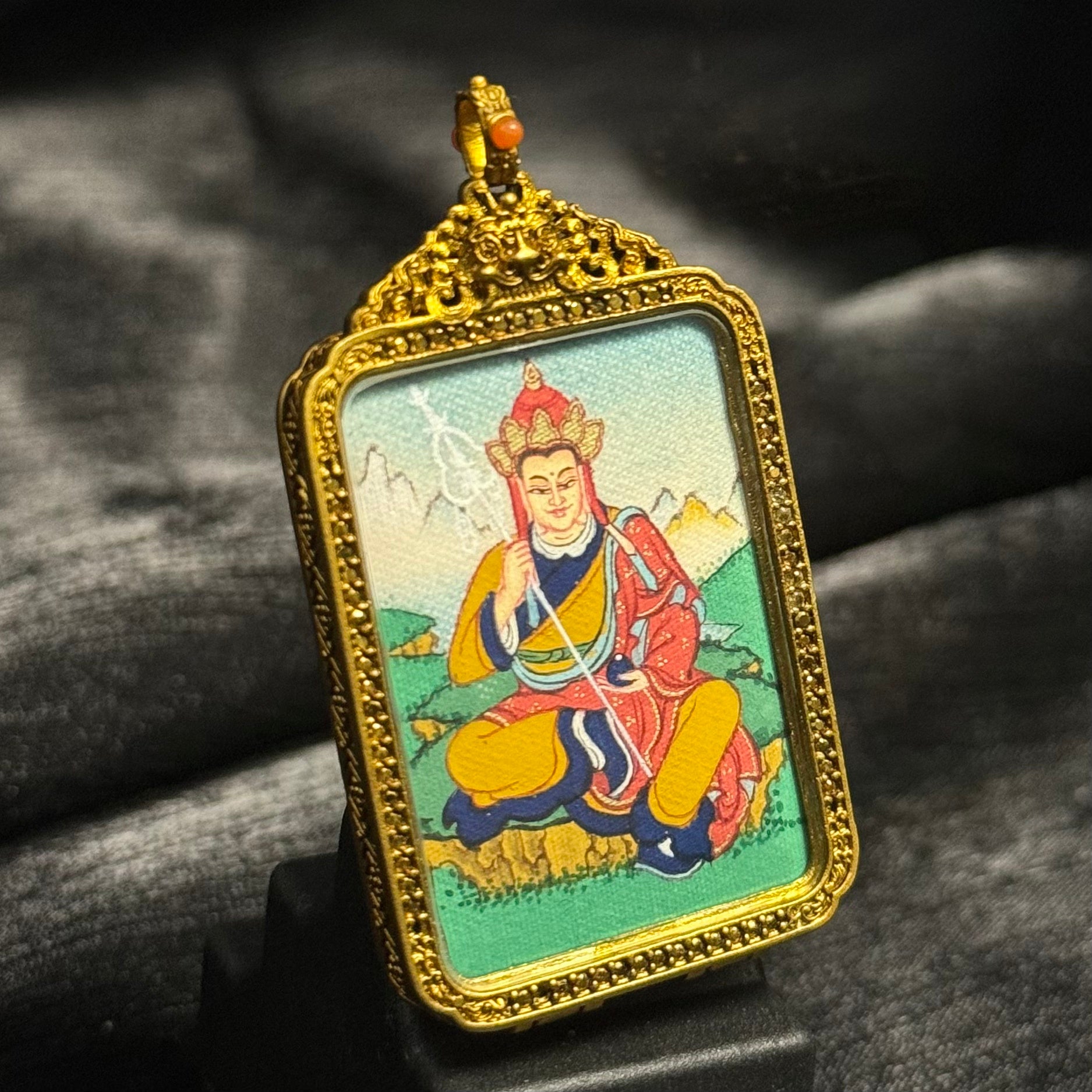 Front view of Ksitigarbha Bodhisattva mini thangka pendant, hand-painted with mineral pigments inside an ornate Tibetan copper protective case