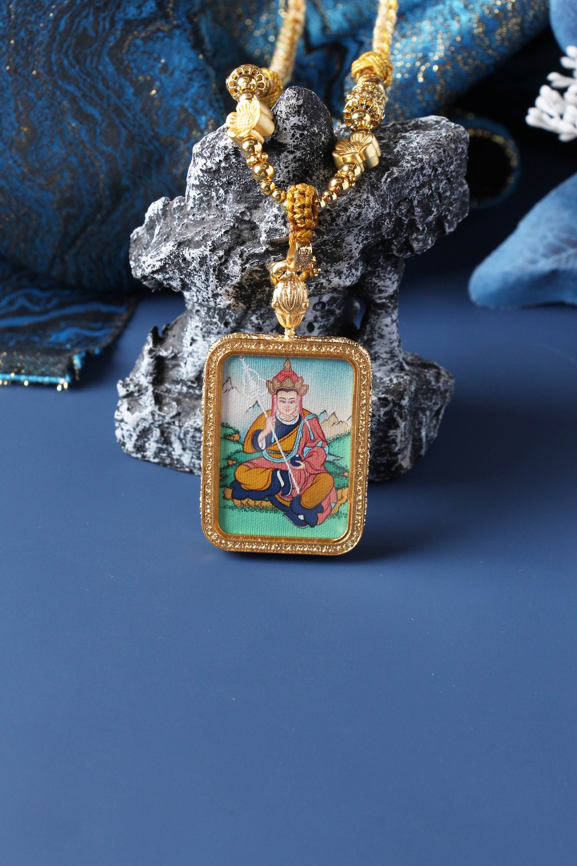 Ksitigarbha mini thangka pendant photographed upright, highlighting rectangular gold-tone double-sided titanium steel case and balanced Tibetan composition
