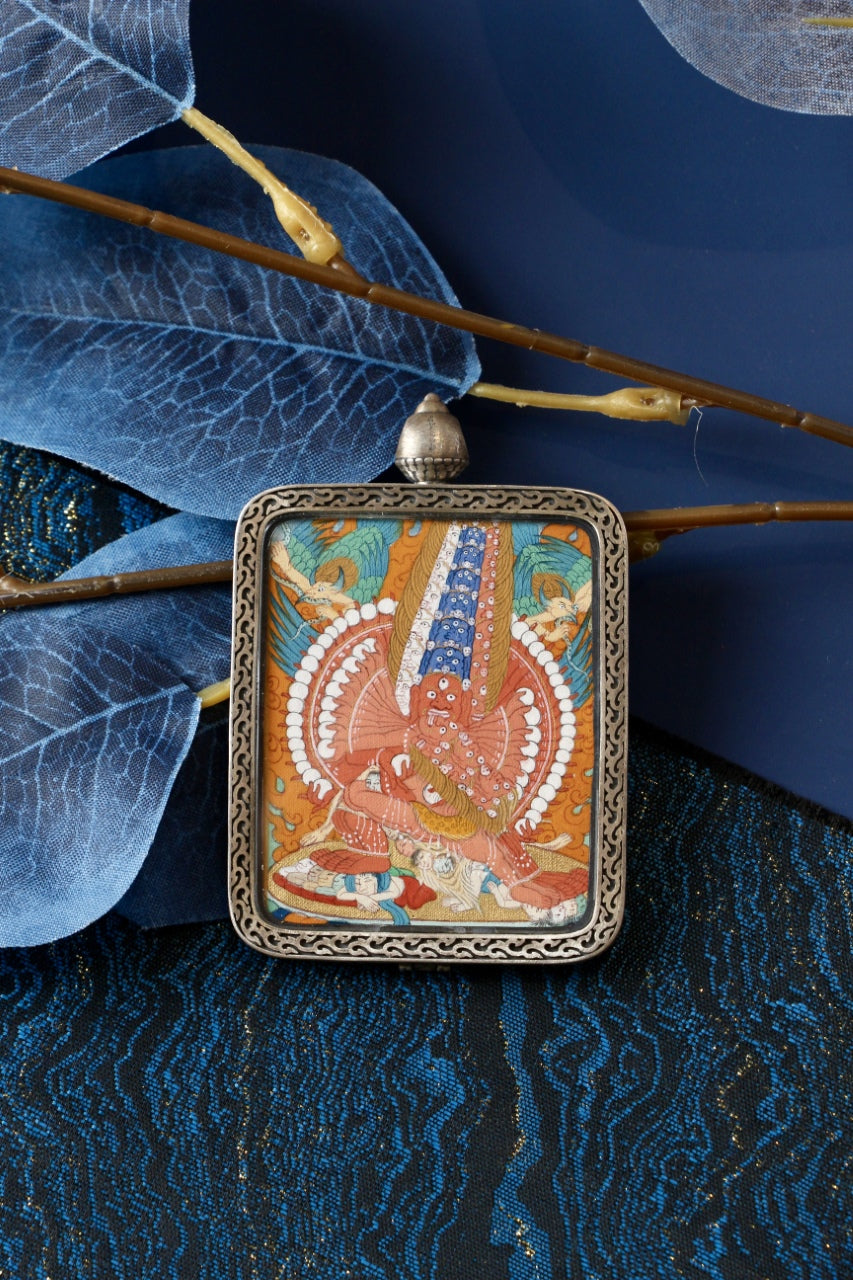 Maha Heruka mini thangka pendant displayed in a portable silver gawu case, suitable for personal shrine or travel use, featuring Tibetan mineral pigment painting