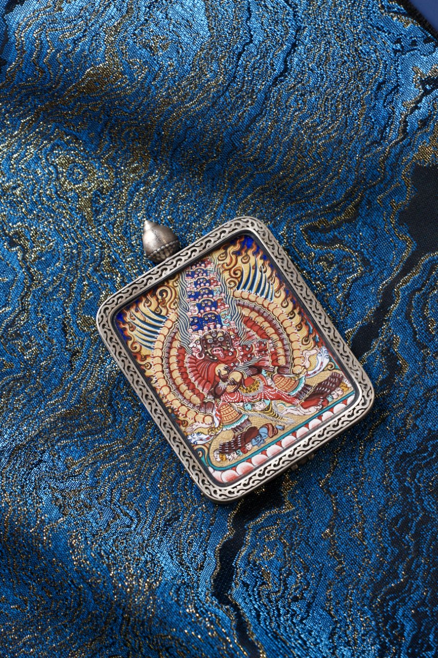 Front view of Maha Heruka mini thangka pendant, hand-painted with mineral pigments in Rebgong style, set in a Dunhuang Nine-Colored Deer silver gawu case
