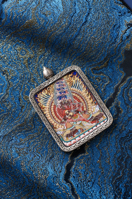 Front view of Maha Heruka mini thangka pendant, hand-painted with mineral pigments in Rebgong style, set in a Dunhuang Nine-Colored Deer silver gawu case