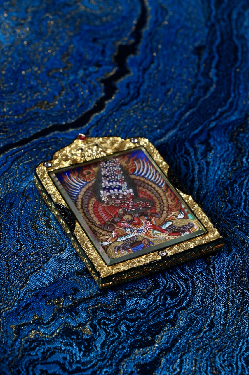 Angled view of Maha Heruka thangka pendant showing double-sided gawu construction, black-gold copper frame, Rebgong hand-painted Tibetan artwork