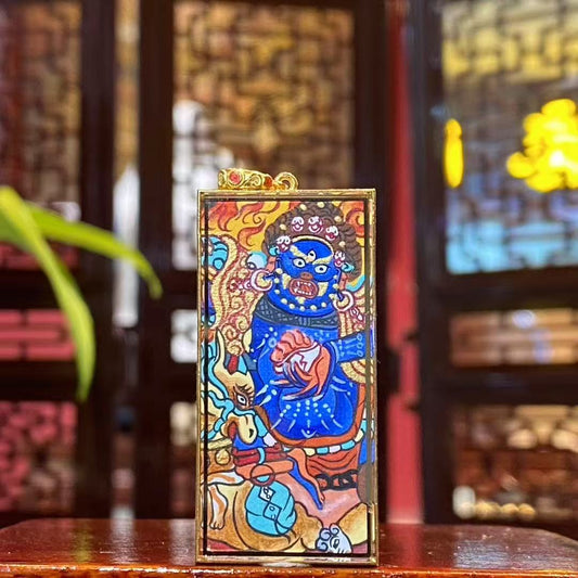 Front view of Mahakala thangka pendant hand-painted in 18K gold, Rebgong style, depicting wrathful protector holding skull cup and riding a blue ox