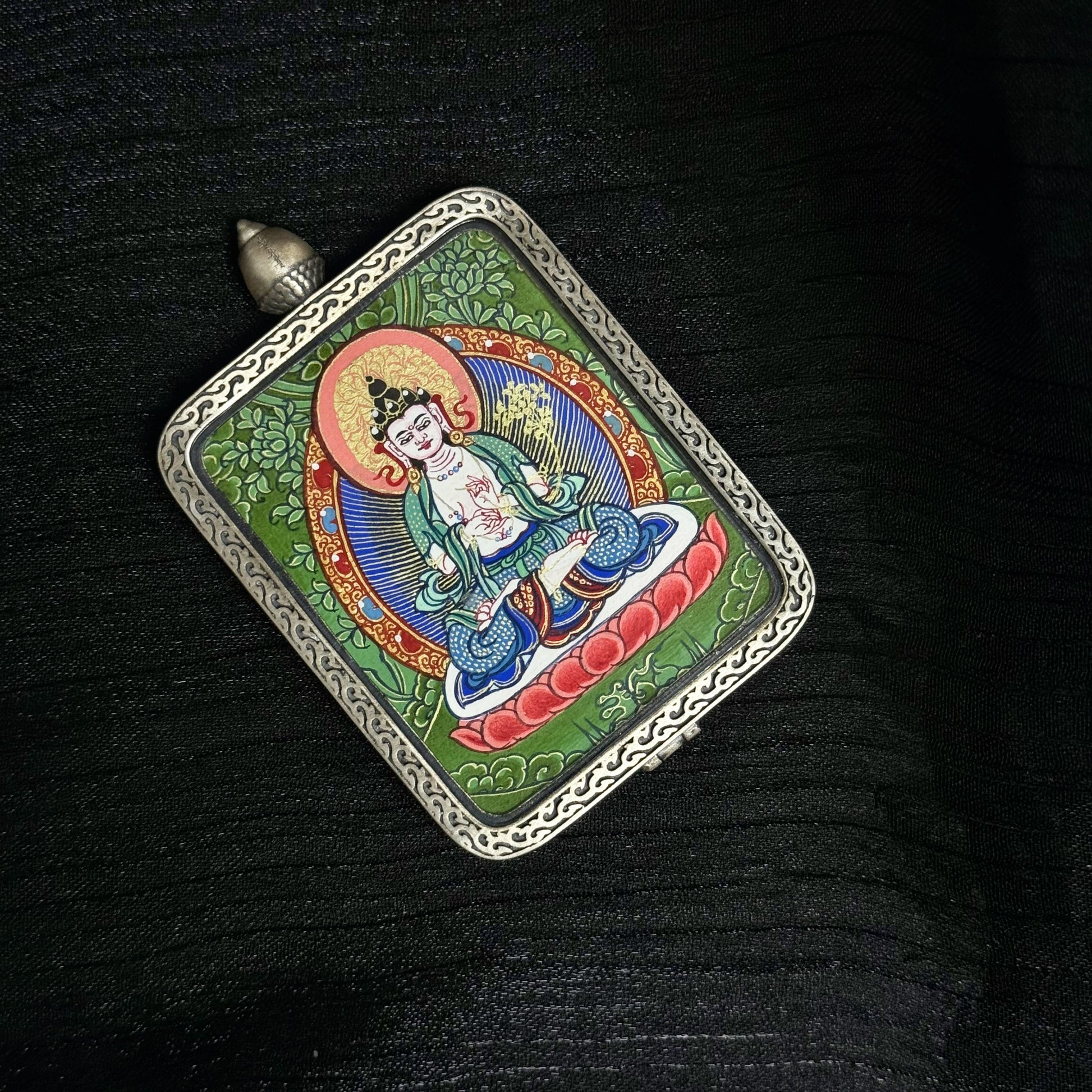 Angled view of Mahasthamaprapta Bodhisattva mini thangka pendant featuring lotus seat, radiant halo, and colorful mineral pigment painting