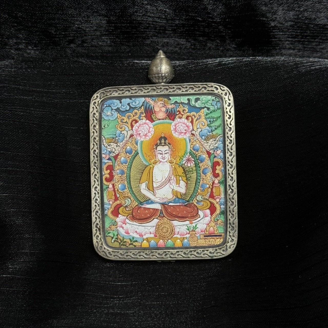 Front view of Mahasthamaprapta Bodhisattva mini thangka pendant, hand-painted with mineral pigments, seated on lotus throne, enclosed in Dunhuang Nine-Colored Deer silver gawu case with engraved border.