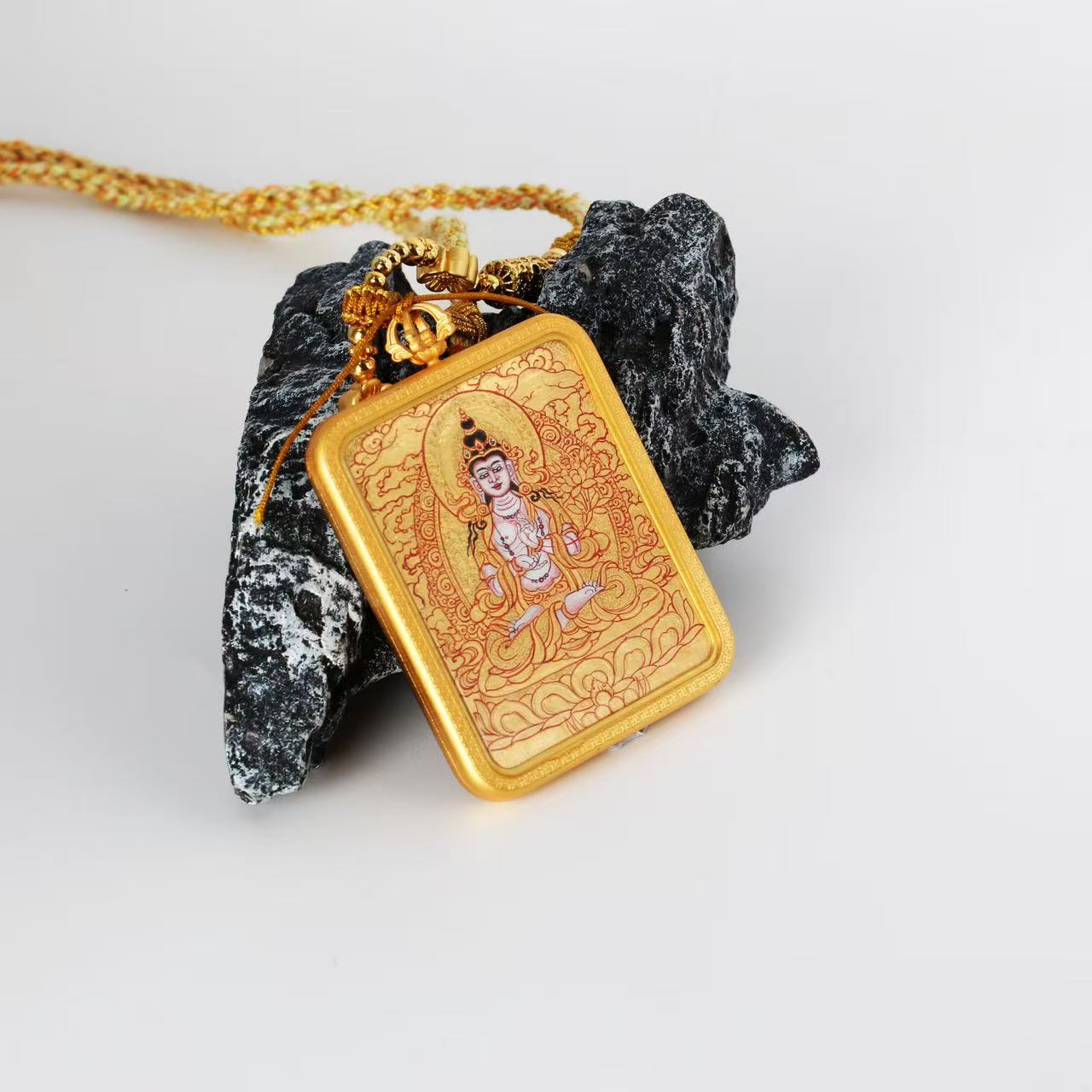 Close-up of the Mahasthamaprapta Bodhisattva mini thangka pendant showing braided cord, decorative metal beads, and handcrafted hanging structure designed for portable use.