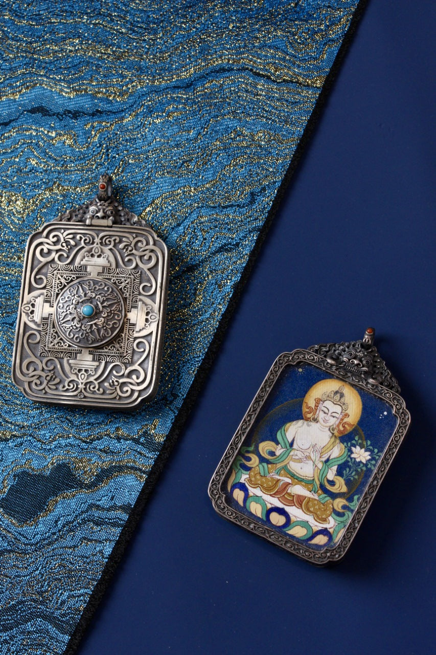 Mahasthamaprapta Bodhisattva thangka pendant shown with its vintage silver case, featuring detailed metalwork and a turquoise-style center accent.