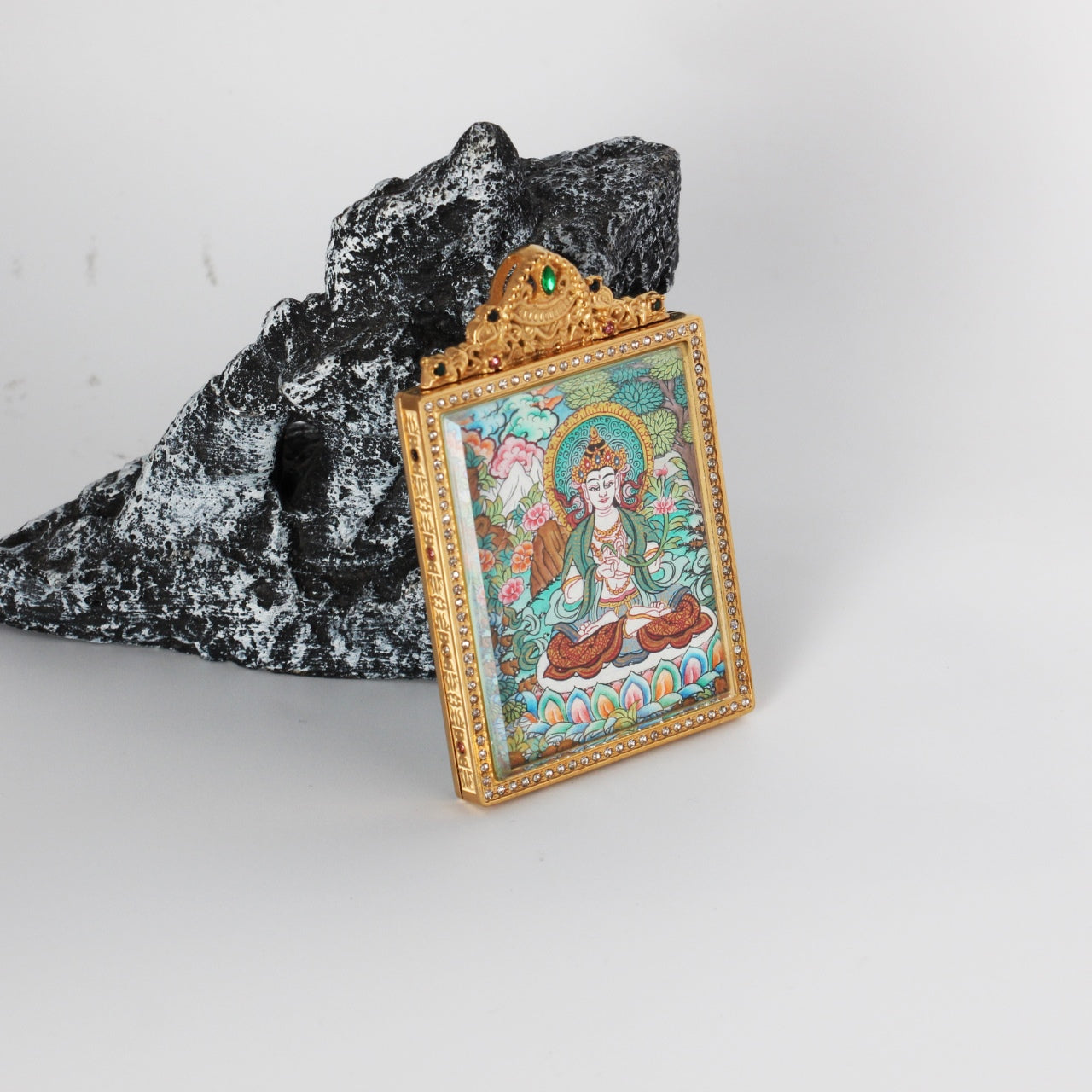 Angled view of Mahasthamaprapta Bodhisattva mini thangka pendant showing the jeweled gold-tone frame and double-sided titanium steel protective case.