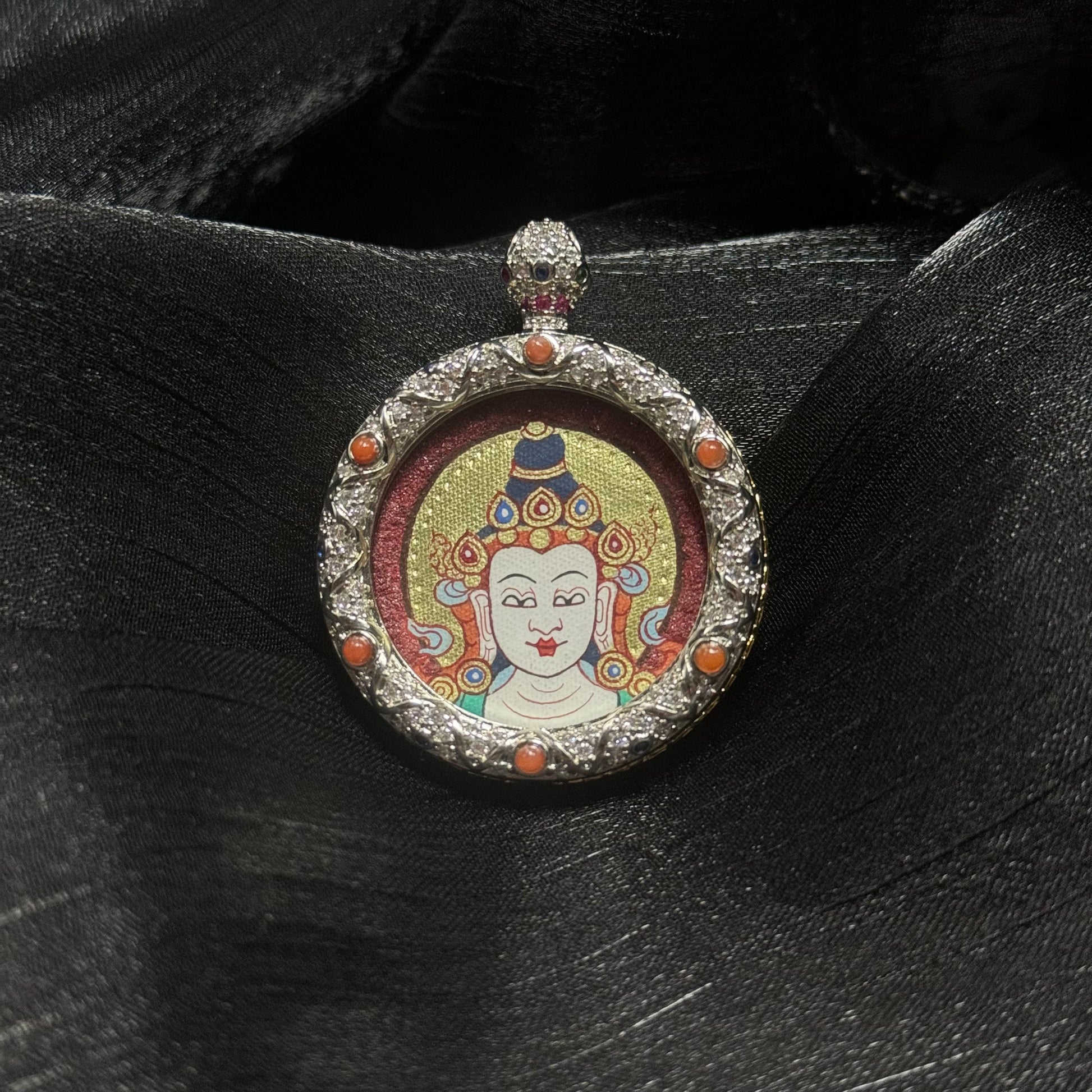 Front view of Mahasthamaprapta Bodhisattva miniature thangka pendant showing traditional Tibetan Rebgong hand-painted Buddha head surrounded by ornate gemstone copper frame