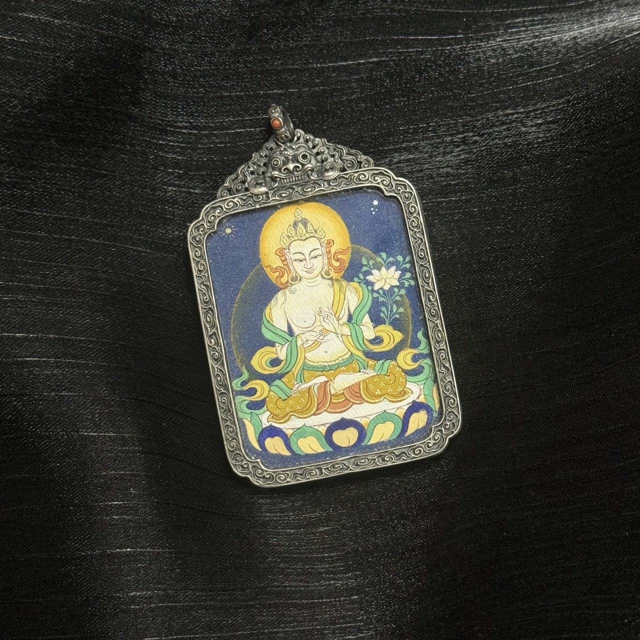 Full view of Mahasthamaprapta Bodhisattva mini thangka pendant, hand-painted in Tibet using mineral pigments, enclosed in an ornate vintage silver frame.