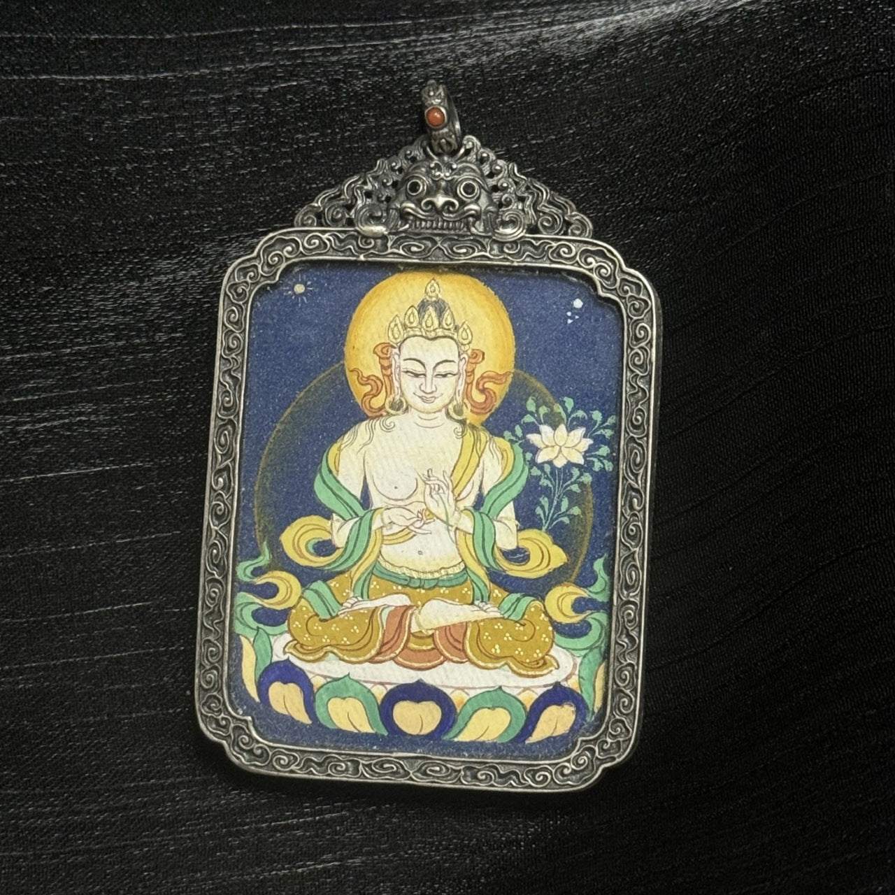 Detailed view of the vintage silver case and frame edges of the Mahasthamaprapta Bodhisattva thangka pendant, highlighting traditional metalwork and protective structure.