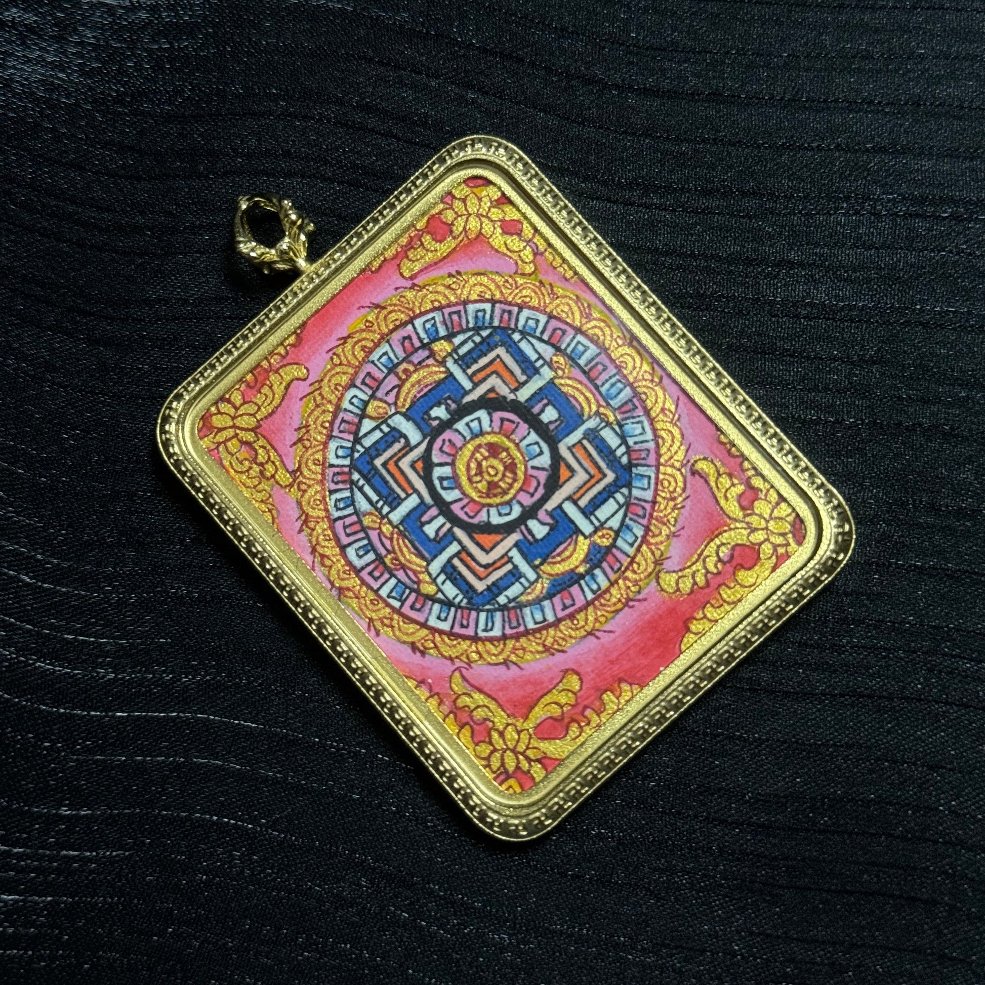 Hand-painted mandala mini thangka pendant displayed at an angle, highlighting intricate sacred geometry and traditional Himalayan thangka craftsmanship.