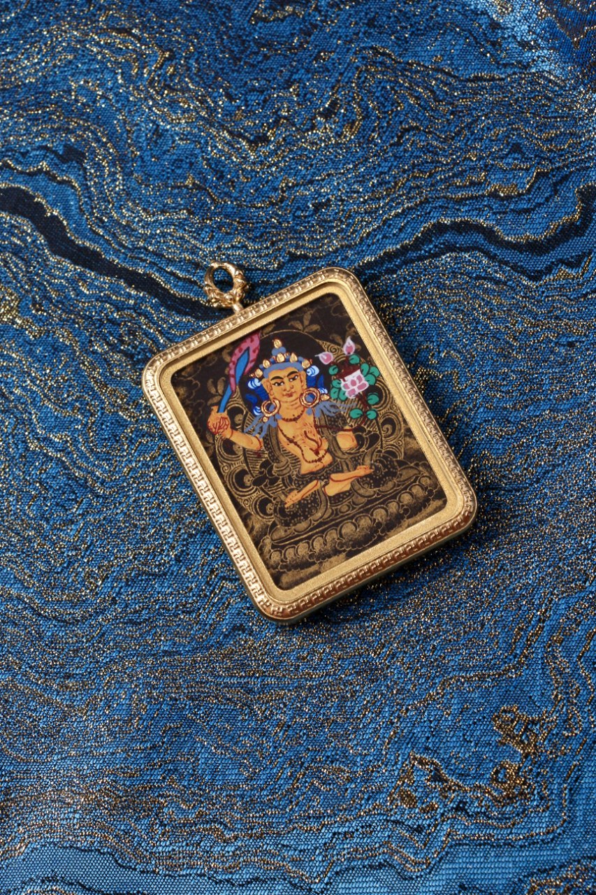 Close-up detail of the Manjushri Black-Gold Mini Thangka Pendant, highlighting the delicate gold linework used to render the deity’s facial features, ritual implements, and ornamental motifs. Painted in the Nepalese black-gold thangka tradition and set within a titanium steel case, this 3.5 × 4.5 cm pendant is suitable for both spiritual devotion and refined collection.