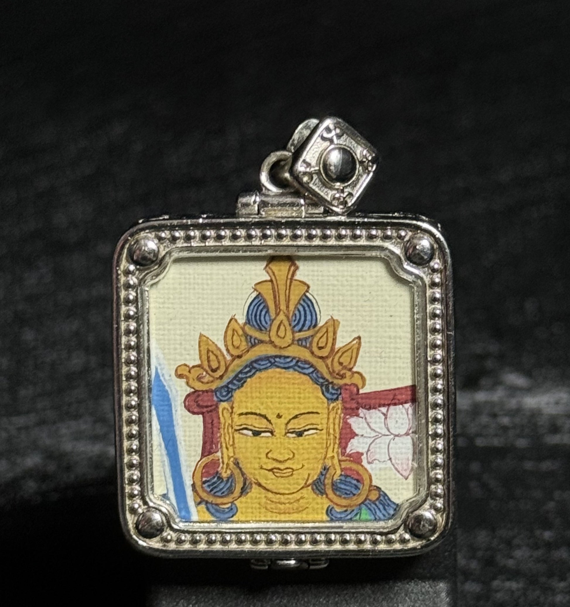 Front view of a hand-painted Manjushri Bodhisattva miniature thangka pendant created with mineral pigments and set in a decorative 925 silver plated frame.