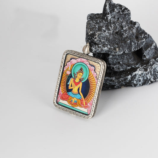 Angled view of the Manjushri Bodhisattva mini Thangka pendant, highlighting layered mineral pigment colors, refined line work, and the thickness of the silver gawu-style frame.