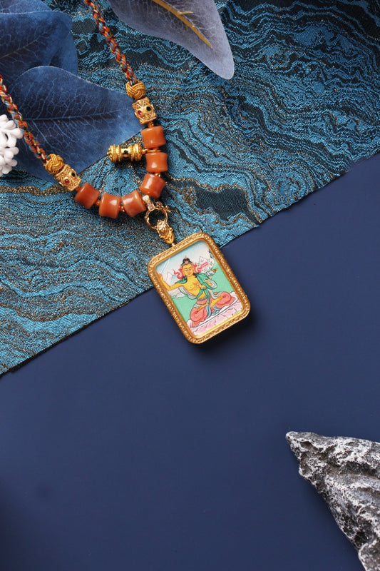 Close-up of Manjushri Bodhisattva mini thangka pendant featuring fine hand-painted details, a rectangular textured metal bezel, and a double-sided titanium steel case