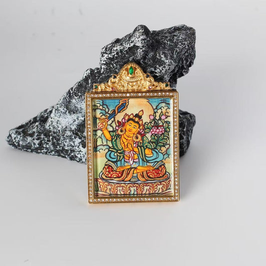 Front view of the Manjushri Bodhisattva mini Thangka pendant featuring a jeweled gold-tone double-sided titanium steel case, crystal border detailing, and a central painted image of Manjushri holding a flaming sword.