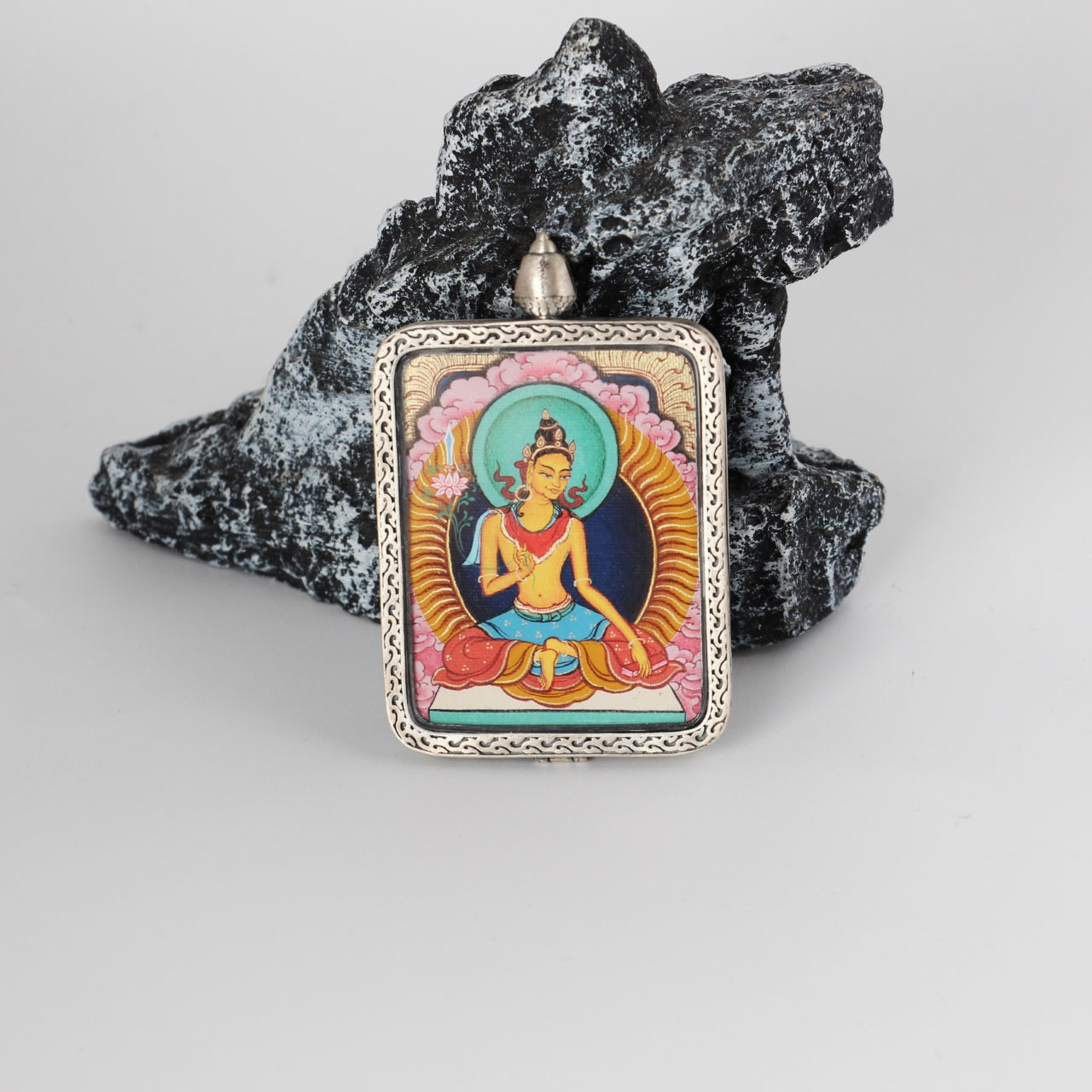 Front view of a Manjushri Bodhisattva mini Thangka pendant, fully hand-painted with mineral pigments and framed in a pure silver gawu-style pendant case with traditional Tibetan decorative patterns.