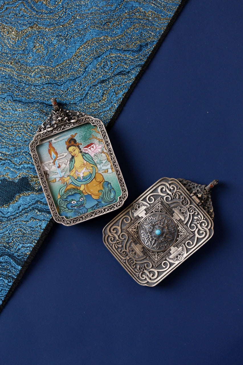 Front and back view of Manjushri Bodhisattva mini thangka pendant, hand-painted with mineral pigments and set in a vintage silver case, Tibetan origin