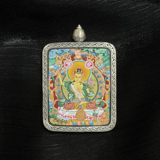 Front view of Manjushri Bodhisattva mini thangka pendant, hand-painted with mineral pigments, holding wisdom sword and lotus, enclosed in Dunhuang Nine-Colored Deer silver gawu case with engraved border.