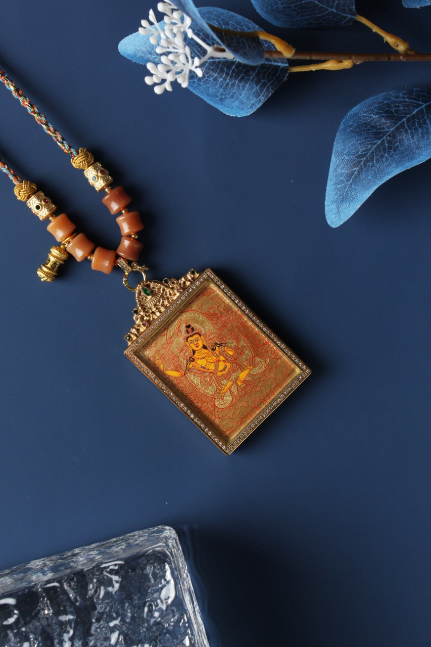 Hand-painted Manjushri Bodhisattva mini thangka pendant in Rebgong gold thangka style, featuring mineral pigment artwork, square double-sided titanium steel case, and ornate top bail with gemstone detail