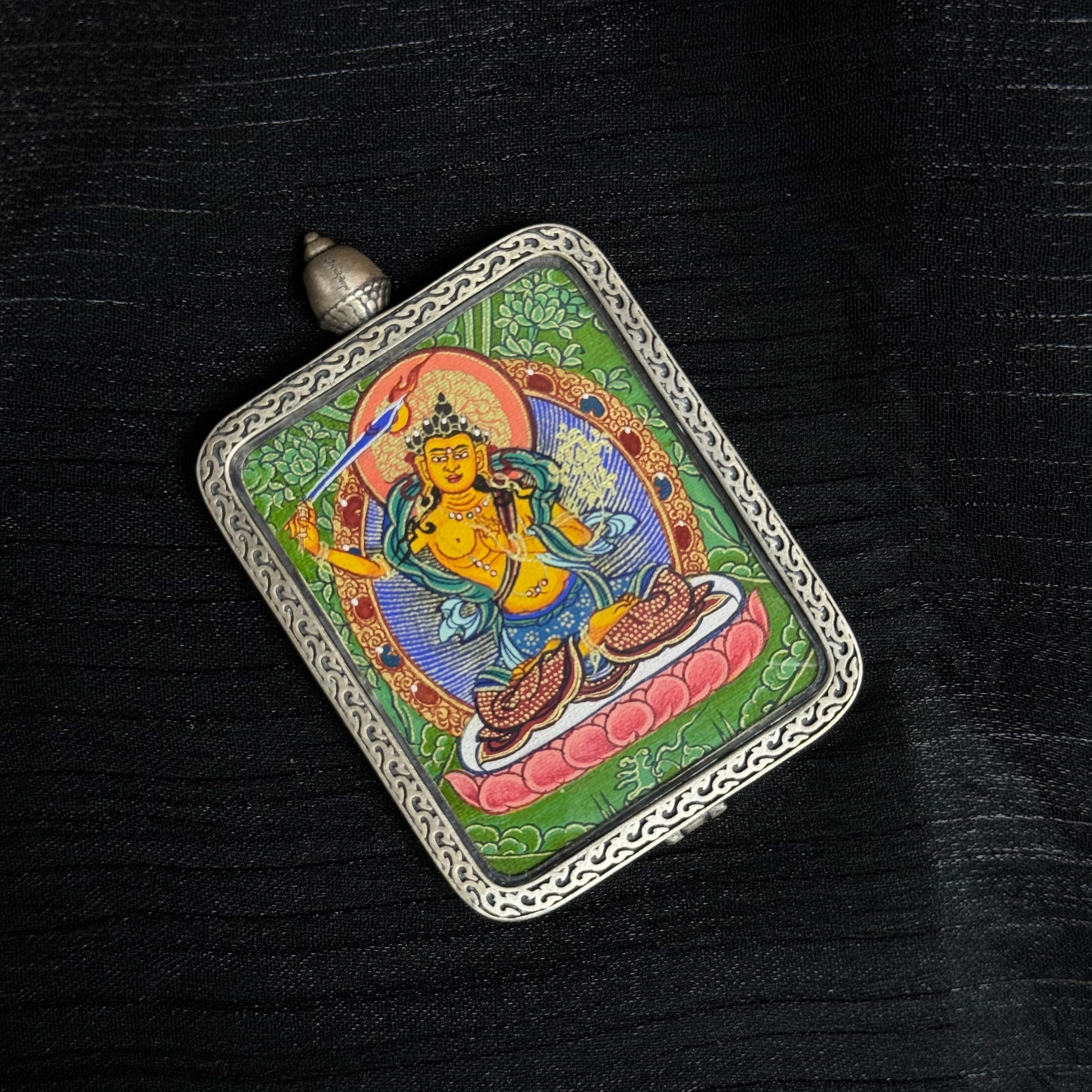 Top angle view of Manjushri Bodhisattva mini thangka pendant highlighting hand-painted Tibetan thangka artwork and ornamental metal frame