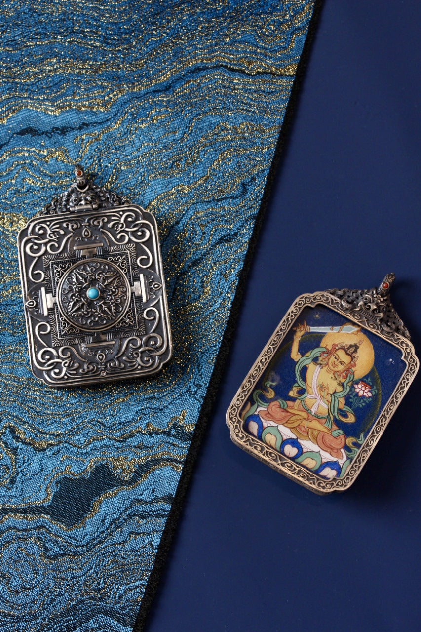 Back and front of the Manjushri mineral-pigment thangka pendant, showing the ornate silver case back and the hand-painted deity image.
