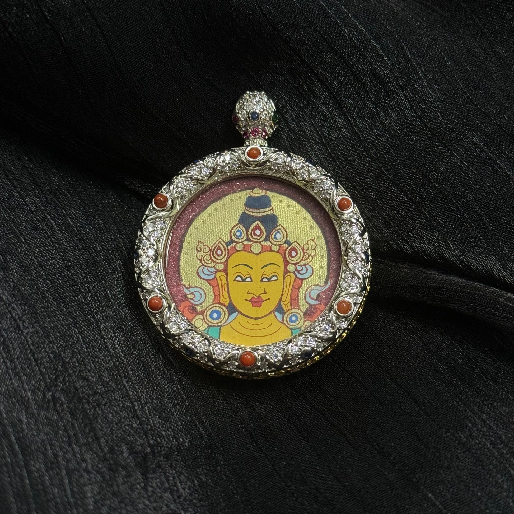 Round Manjushri Bodhisattva thangka pendant with detailed jeweled copper frame and traditional Tibetan hand-painted portrait on mineral pigment background.