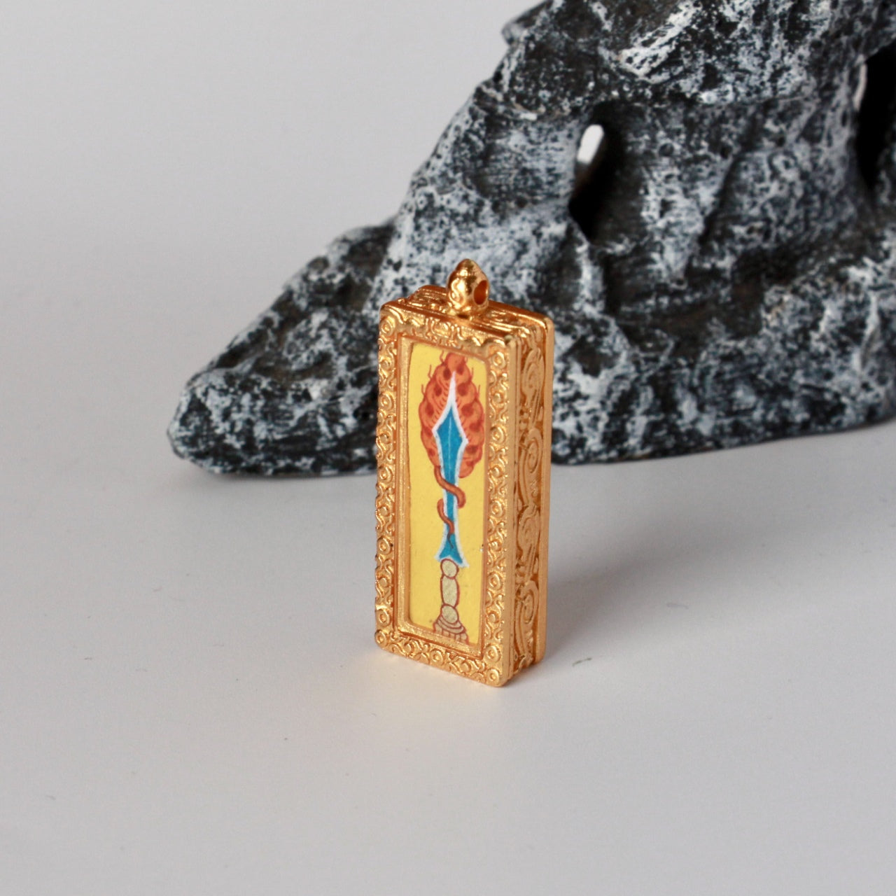 Angled view of the Manjushri Wisdom Sword mini thangka pendant showing the thickness and engraved details of the traditional copper casing.