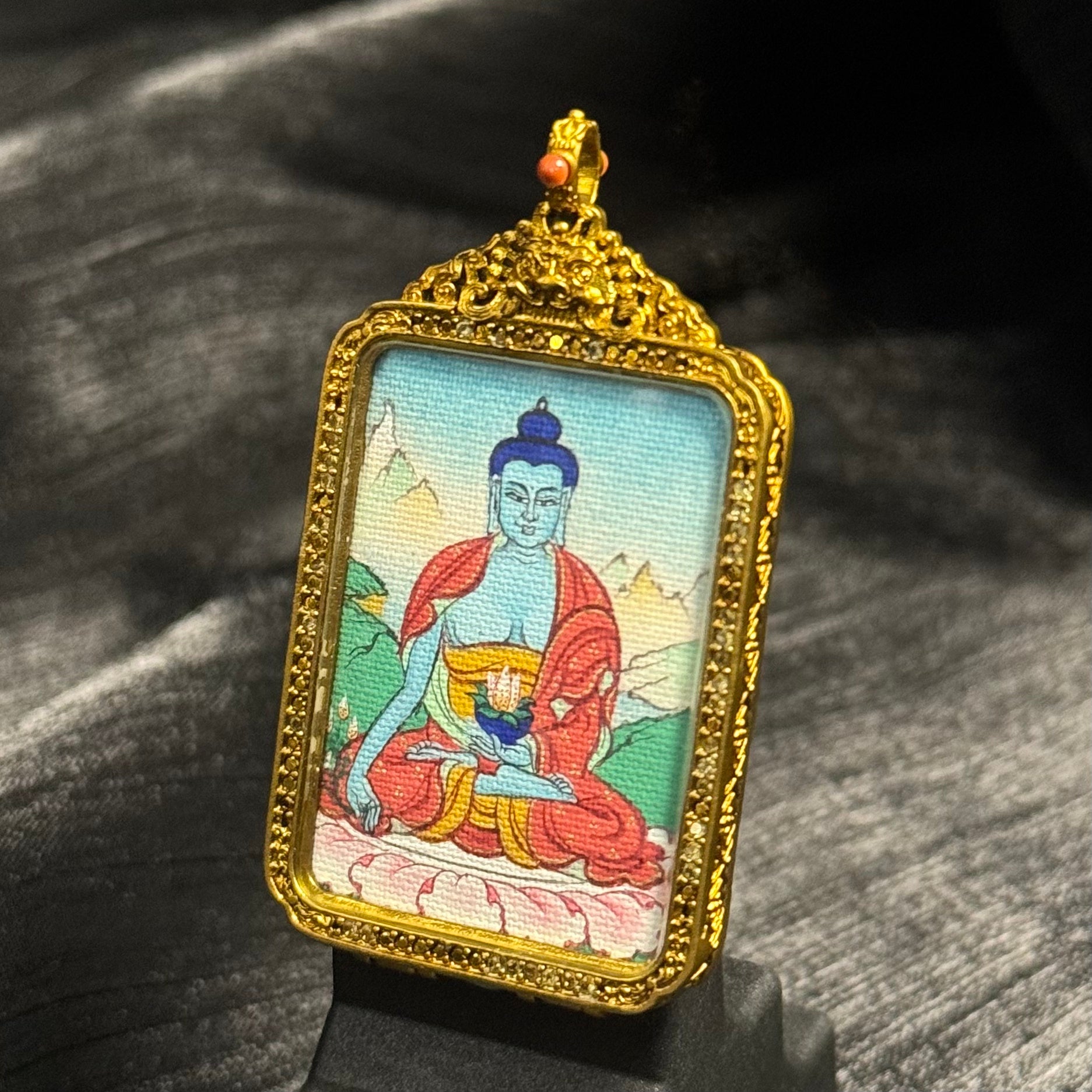 Close front view of Medicine Buddha miniature thangka painting with traditional mineral pigments inside a copper pendant case