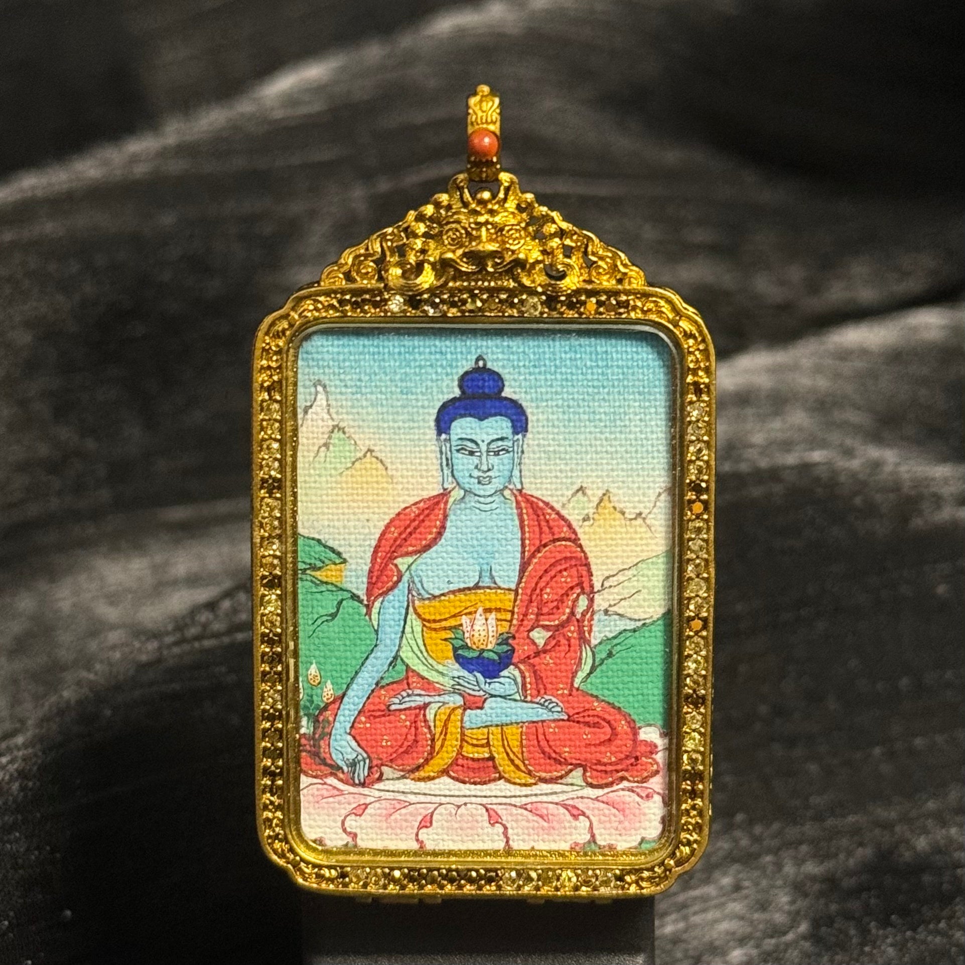 Front view of Medicine Buddha mini thangka pendant hand-painted with mineral pigments and set in an ornate Tibetan copper protective case