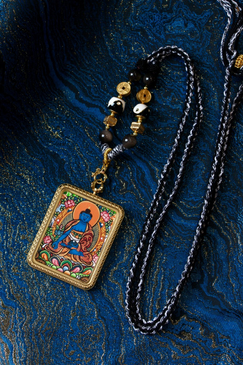 Nepalese hand-painted Medicine Buddha mini thangka pendant displayed with braided cord and bead details, titanium steel frame, portable Buddhist art