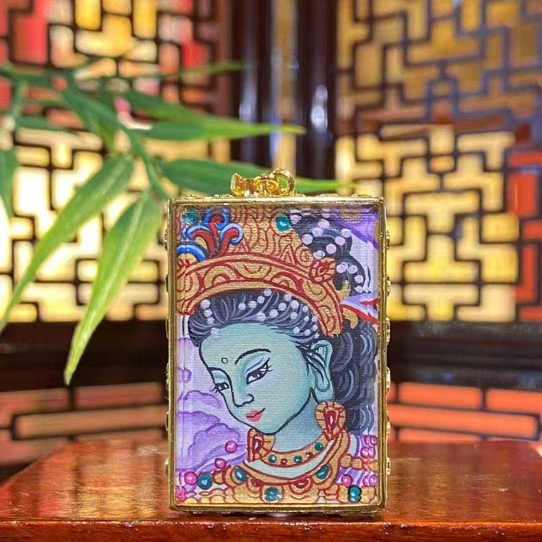 Front view of a mini hand-painted Green Tara Gau Thangka pendant showing a gentle half-profile Green Tara portrait in a copper gau box