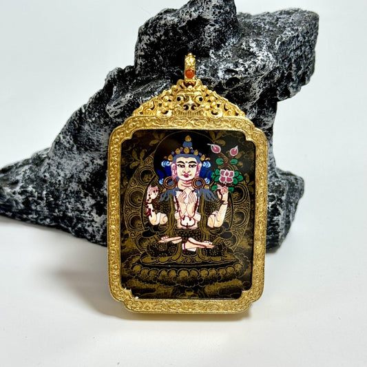 Front view of Nepal Black Gold Series Four-Armed Avalokiteshvara pendant, black-and-gold thangka artwork under glossy cover, set in an ornate gold-tone carved frame.