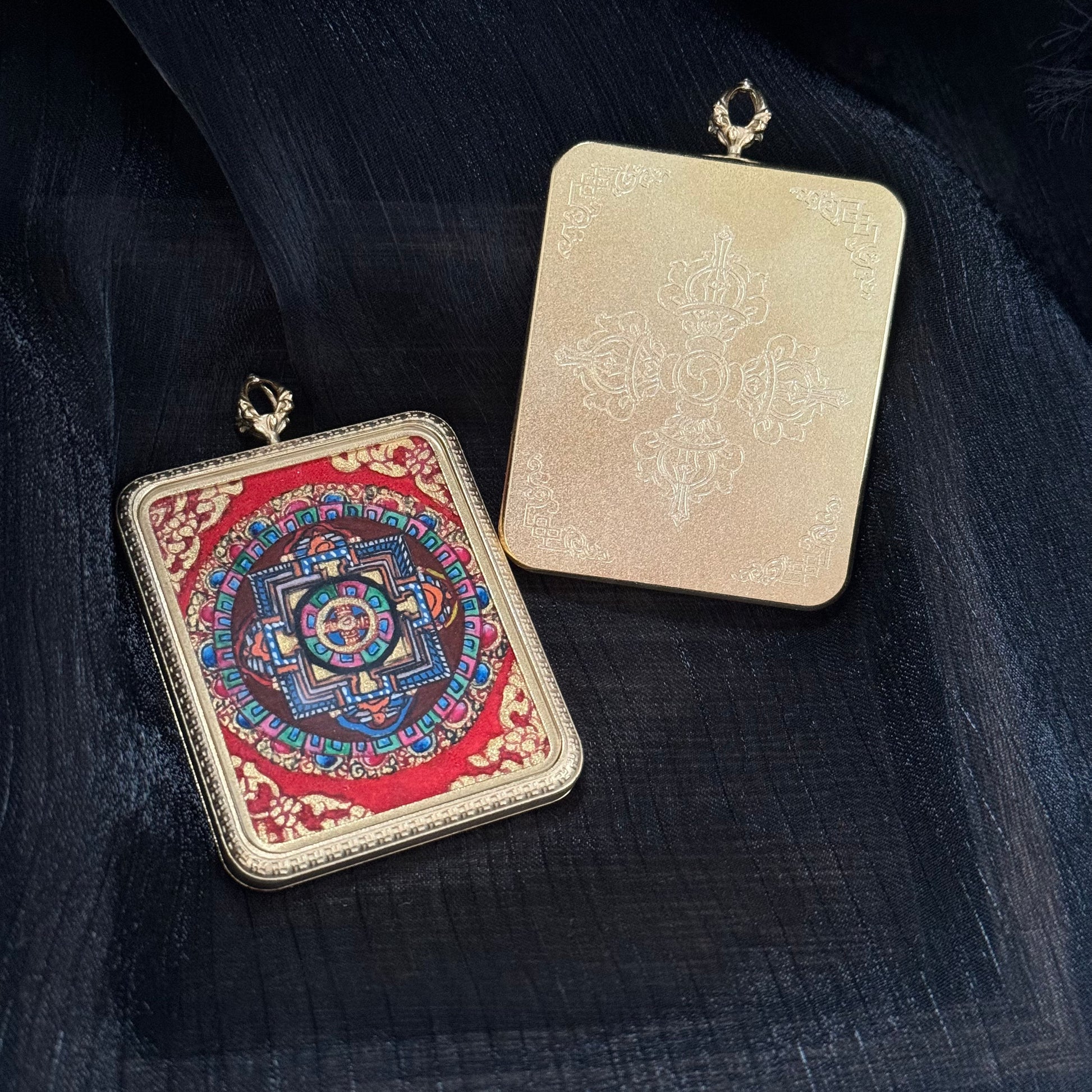 Front and back view of a Nepal mandala mini thangka pendant showing the colorful mandala painting on the front and an engraved vajra symbol on the back of the gold-tone pendant case.