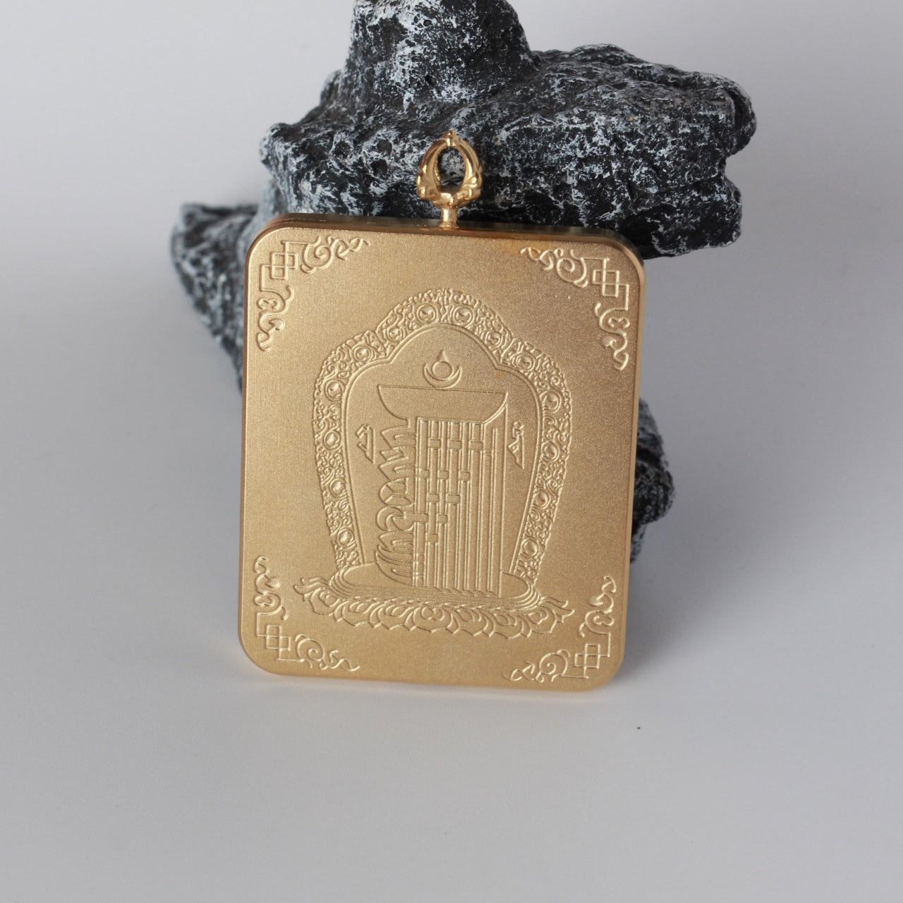 Back view of featuring an embossed central auspicious motif with decorative corner patterns on a matte-textured gold-tone titanium steel case.