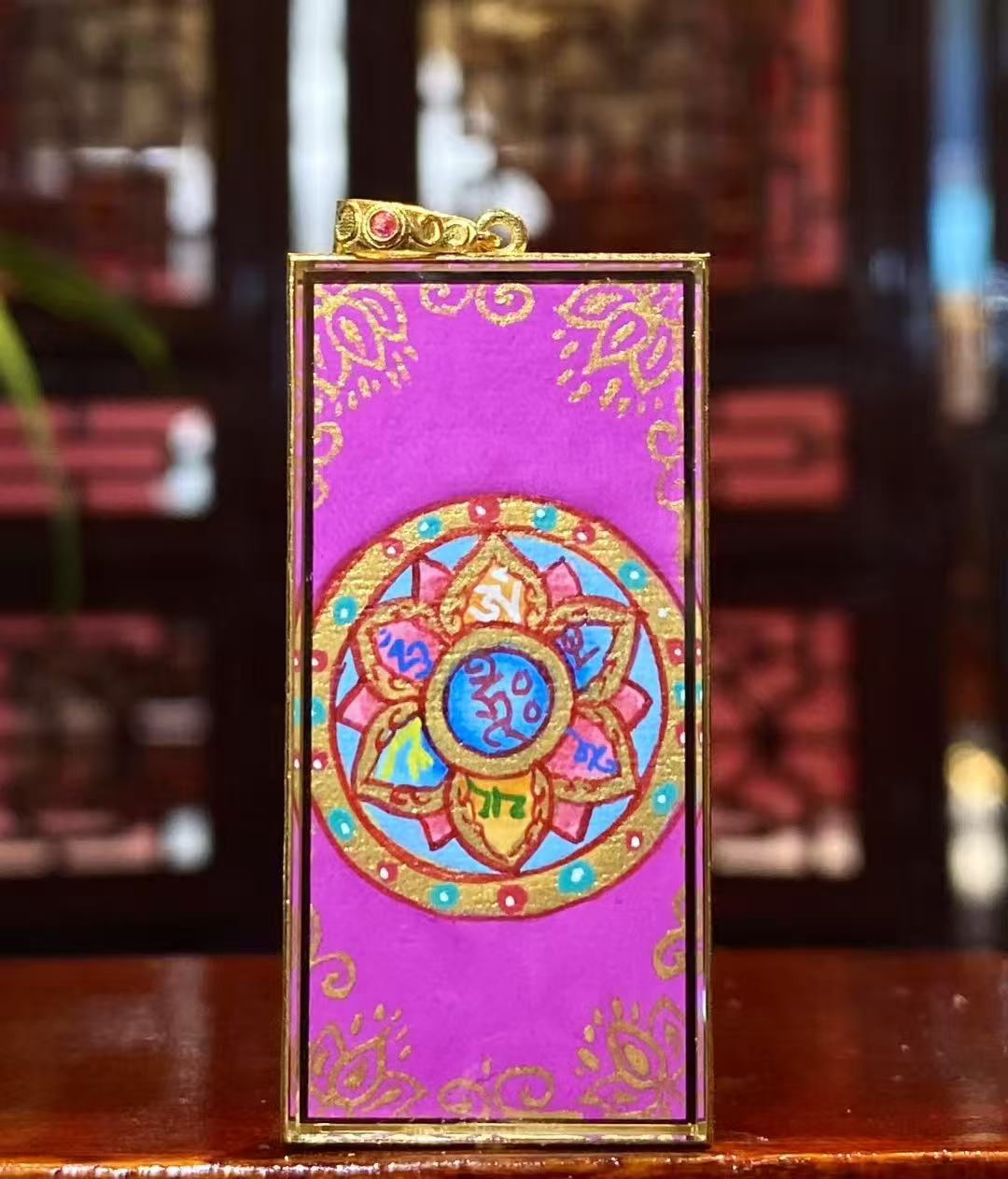Back view of a double-sided Thangka pendant featuring the Six-Syllable Mantra Om Mani Padme Hum, fully hand-painted with 18K gold in Rebgong tradition.
