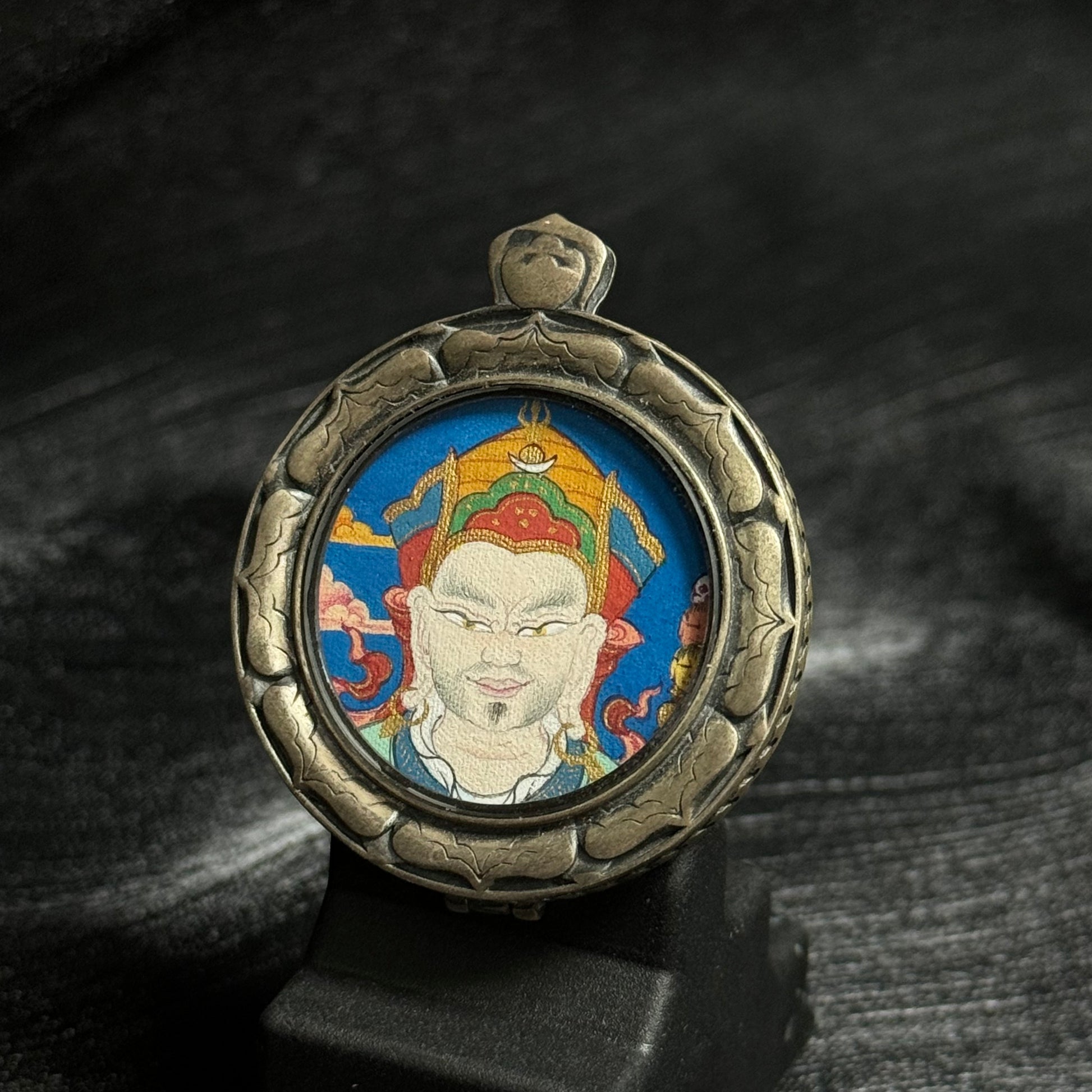 Close-up of the circular Guru Rinpoche thangka painting highlighting the detailed facial features, traditional crown, and vivid mineral pigment colors.