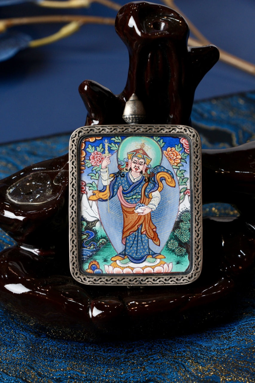 Close-up front view of Padmasambhava standing form mini thangka pendant in an ornate silver gawu-style frame