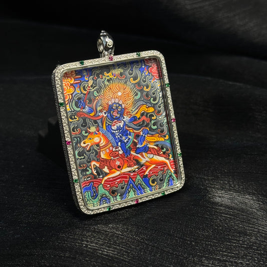 Angled view of Palden Lhamo Rebgong mini thangka pendant showing detailed mineral pigment painting, gold powder highlights, and gemstone decorated pendant frame.