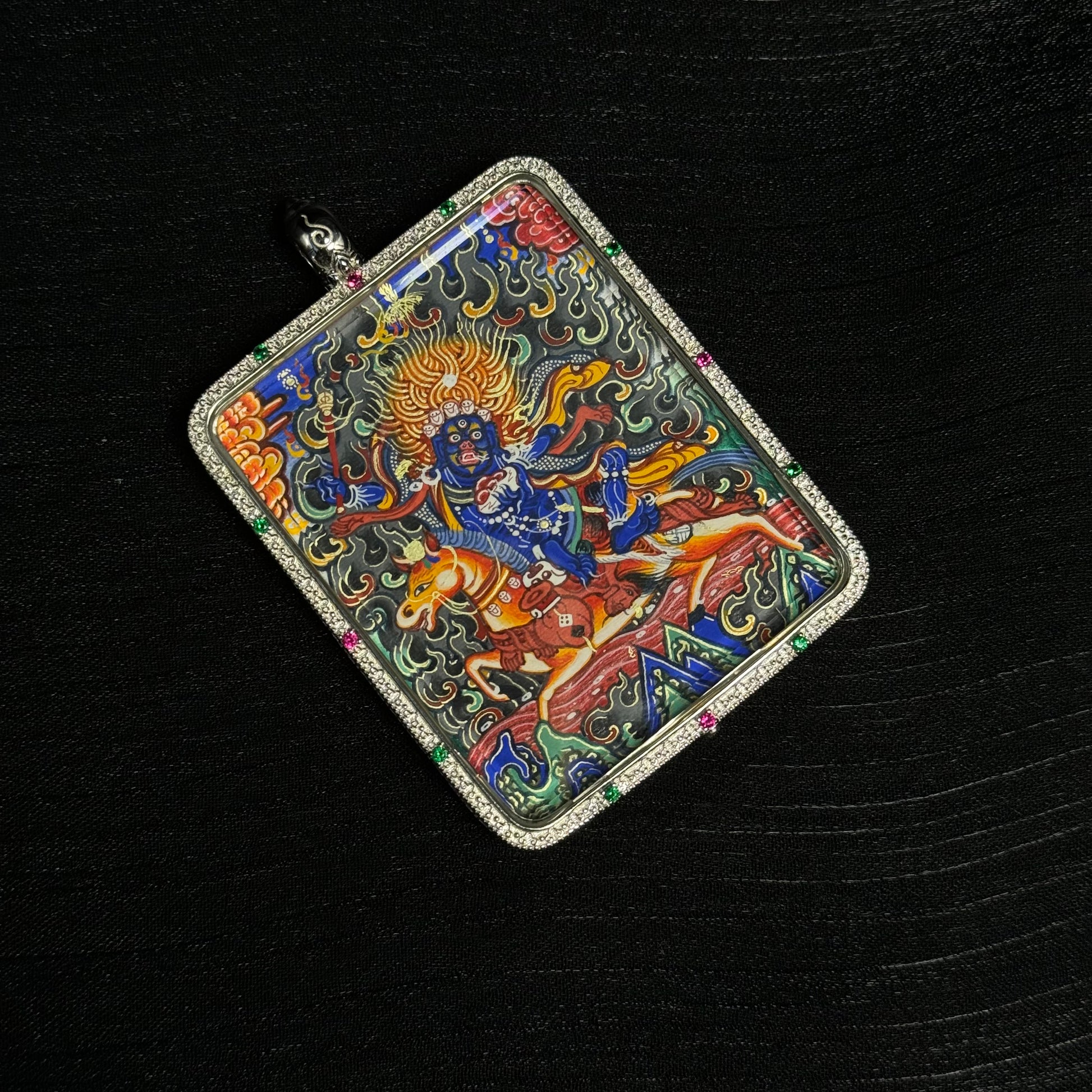 Detailed view of Palden Lhamo Rebgong mini thangka pendant displaying hand-painted mineral pigment artwork, gold powder highlights, and ornate gemstone frame.