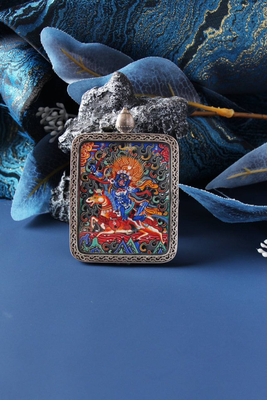 Close-up of a Palden Lhamo (Shri Devi) thangka pendant, hand-painted in Rebgong style with natural mineral pigments and gold powder, set in a 925 silver case.