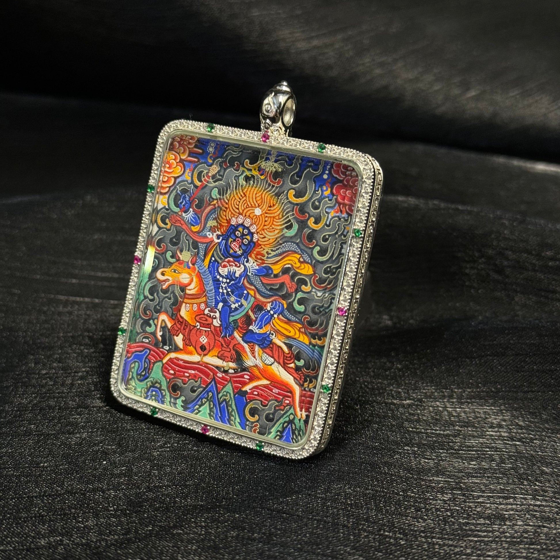 Close angled view of Palden Lhamo mini thangka pendant highlighting Rebgong fine linework, layered mineral pigments, and vivid Tibetan protector deity imagery.