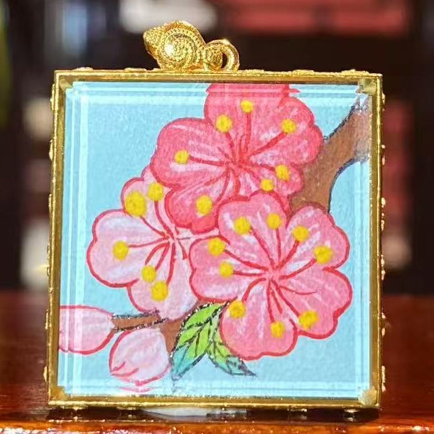 Back view of double-sided Tibetan mini thangka pendant with hand-painted peach blossom symbol, representing harmony and vitality in traditional art